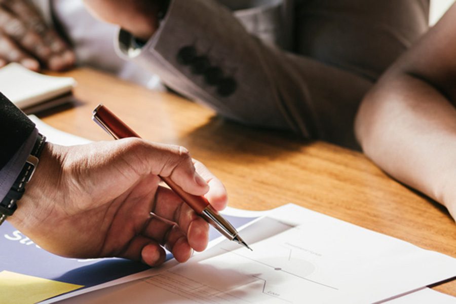 Financial Advisor hand with pen and paperwork